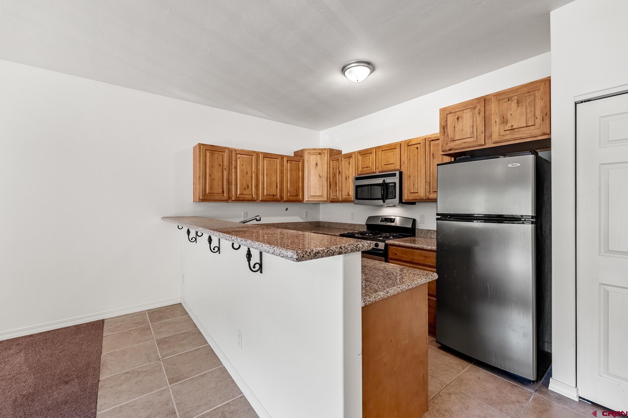 33 Cedar Ridge Way, Unit 3 Durango, CO 81301 - Photo 11 of 31 a kitchen with stainless steel appliances granite countertop a refrigerator and a stove