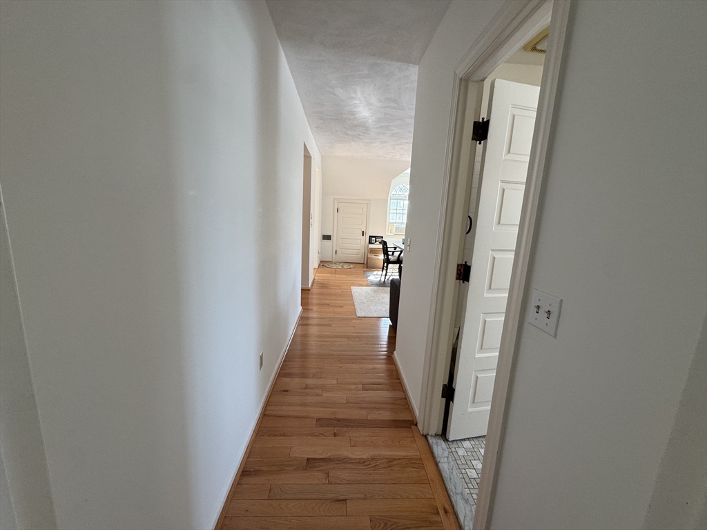 600 Washington Street, Unit 7 Wellesley, MA 02482 - Photo 3 of 13 a view of a hallway with wooden floor and a bathroom