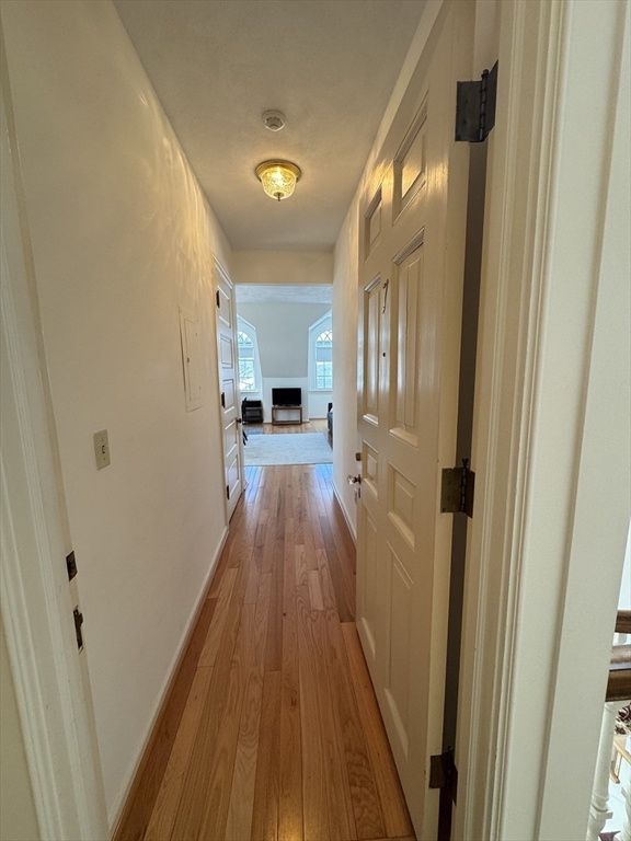 600 Washington Street, Unit 7 Wellesley, MA 02482 - Photo 5 of 13 a view of a hallway with wooden floor and a bathroom