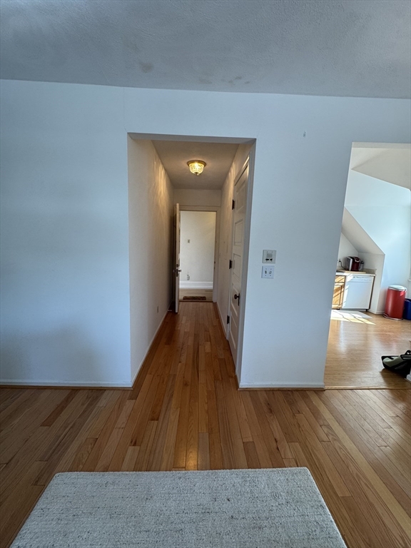 600 Washington Street, Unit 7 Wellesley, MA 02482 - Photo 6 of 13 a view of a hallway with wooden floor and furniture