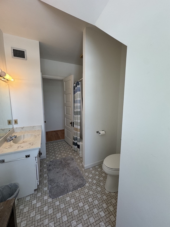 600 Washington Street, Unit 7 Wellesley, MA 02482 - Photo 7 of 13 a bathroom with a granite countertop sink a toilet and a mirror