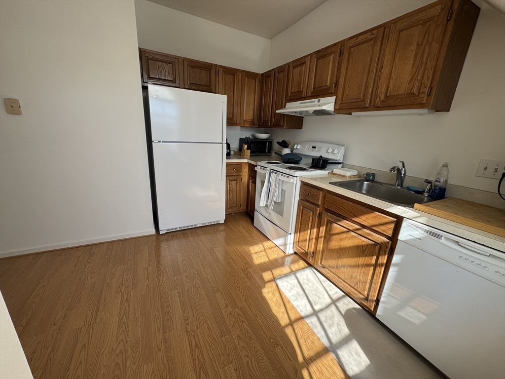 600 Washington Street, Unit 7 Wellesley, MA 02482 - Photo 8 of 13 a kitchen with a refrigerator a stove a sink and a dishwasher with wooden floor