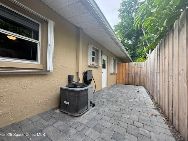 a view of backyard with barbeque grill and wooden fence