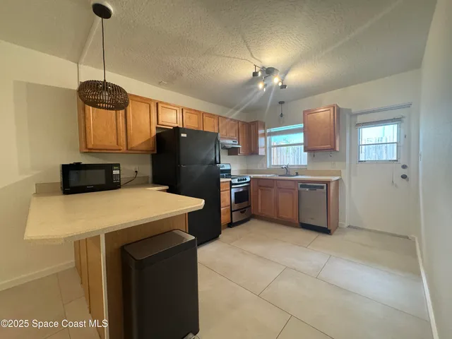 a kitchen with stainless steel appliances a stove a refrigerator and a sink