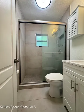 a bathroom with a toilet and a shower