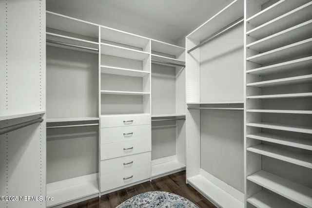 a dining room with furniture a floor to ceiling window and wooden floor