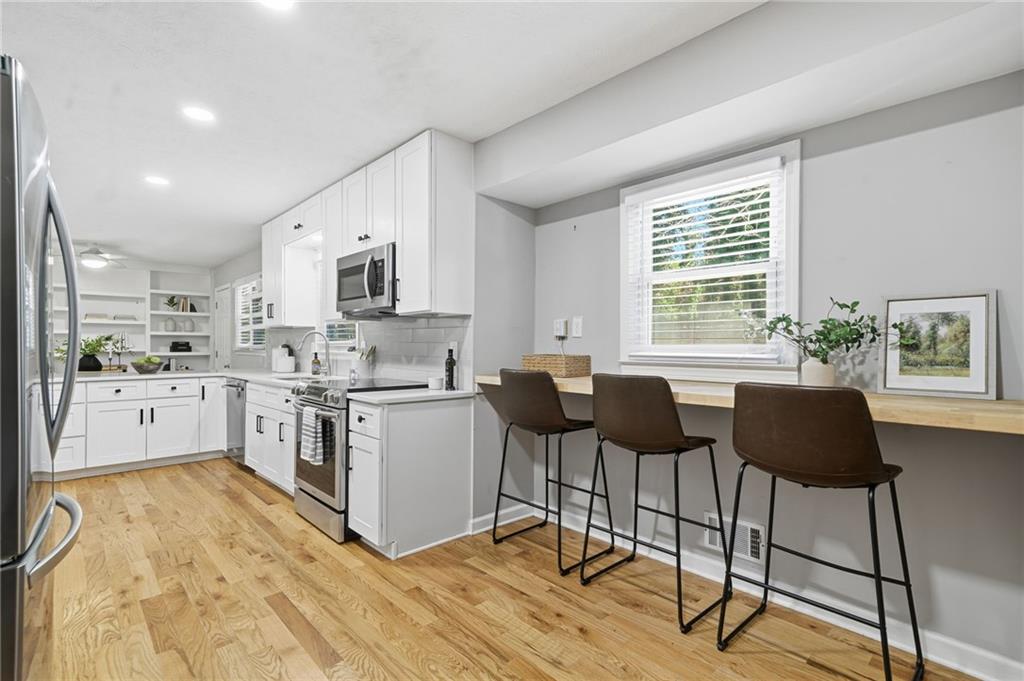 111 John Christopher Drive Alpharetta, GA 30009 - Photo 14 of 30 a kitchen with granite countertop a stove a sink and a refrigerator