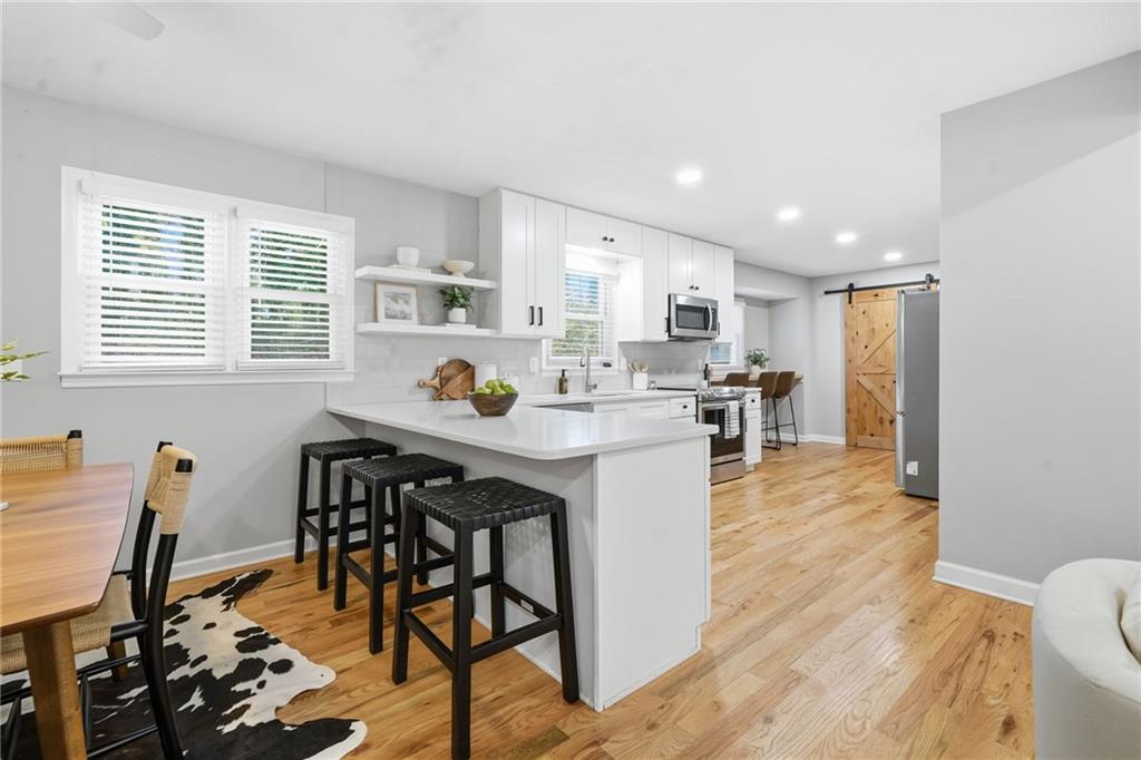 111 John Christopher Drive Alpharetta, GA 30009 - Photo 10 of 30 a kitchen with stainless steel appliances granite countertop a table chairs and a refrigerator