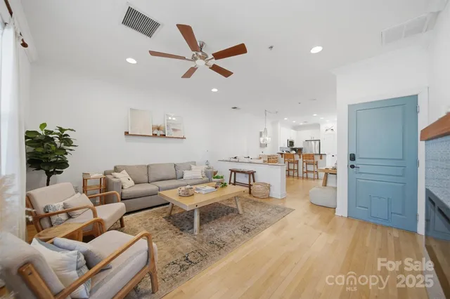 a living room with furniture and a wooden floor