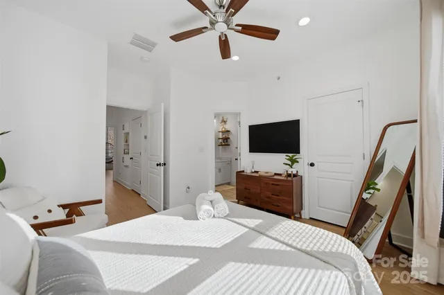 a bedroom with a bed and a flat tv screen on dresser