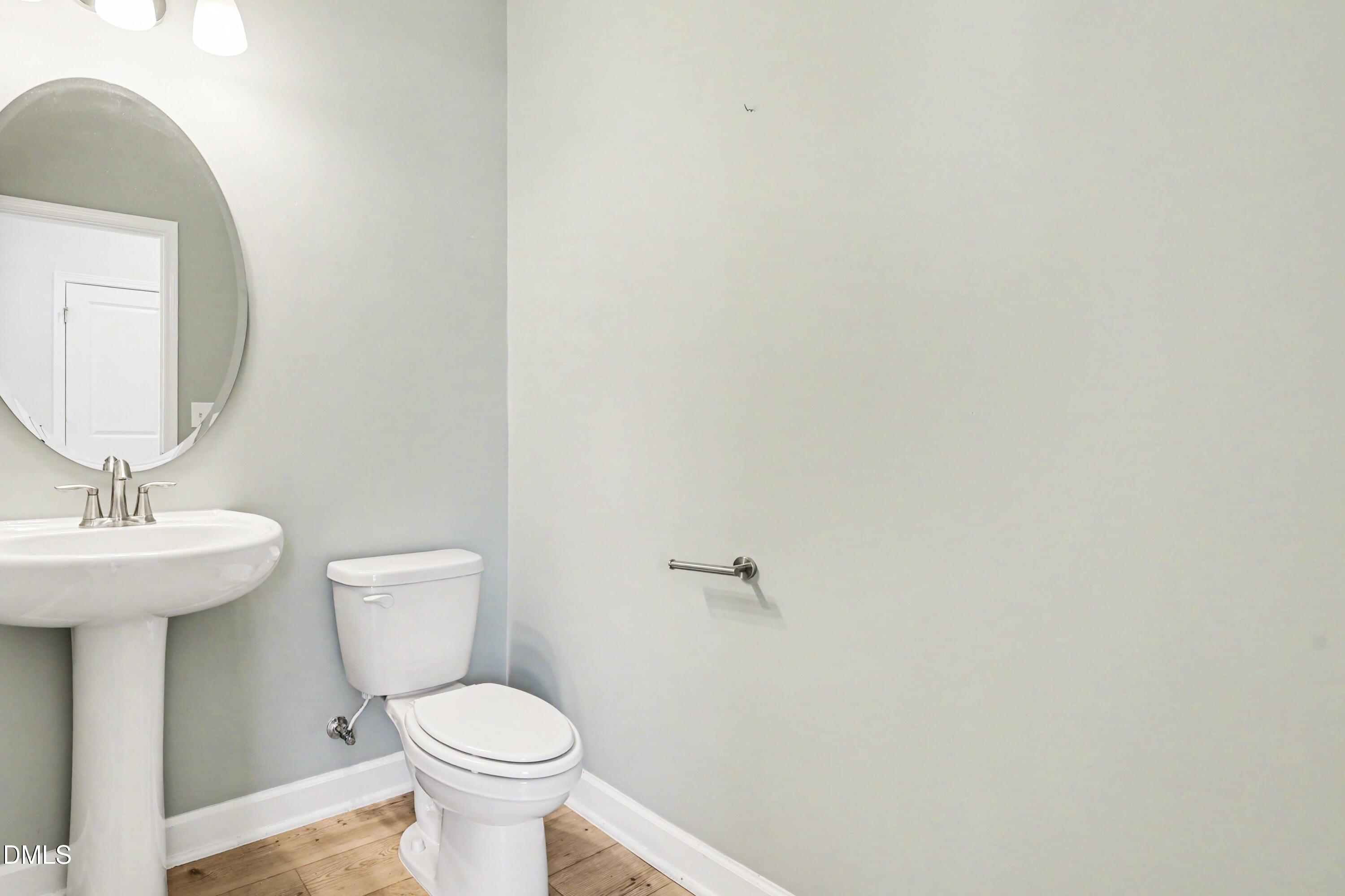 90 Rigsby Avenue Four Oaks, NC 27524 - Photo 30 of 43 a bathroom with a toilet a sink and mirror