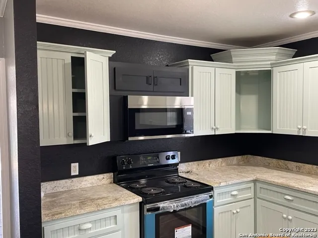 a kitchen with granite countertop a stove and a microwave