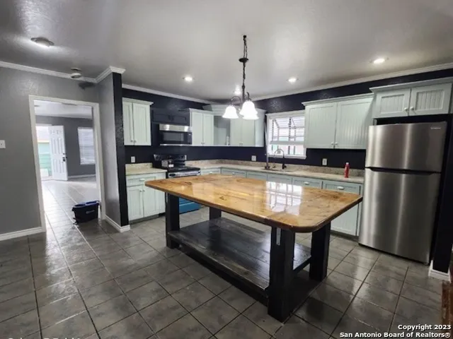 a kitchen with a wooden floor and chandelier
