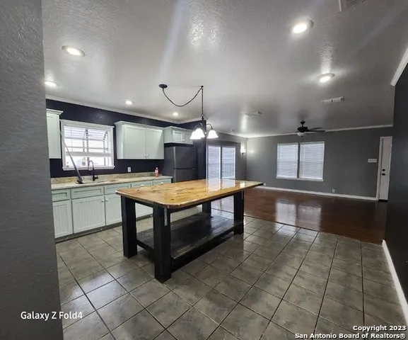 a sink with granite countertop white cabinets and a sink