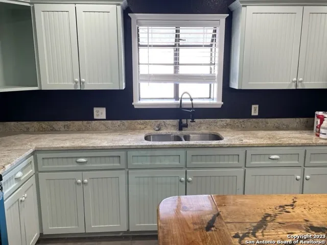 a room with pool table and windows