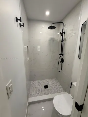 a bathroom with a shower a toilet and sink