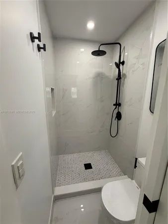 a bathroom with a shower a toilet and sink