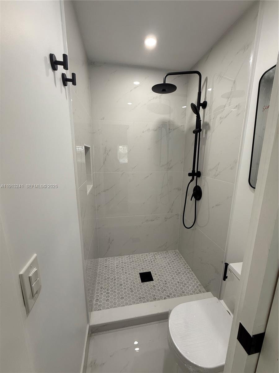 5636 Northwest 4th Avenue, Unit STUDIO Miami, FL 33127 - Photo 5 of 7 a bathroom with a shower a toilet and sink