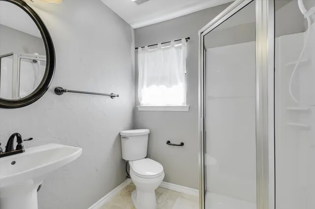 a bathroom with a toilet a sink and a mirror