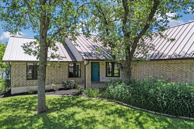 a view of a house with a tree in front of it