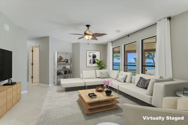 a living room with furniture a flat screen tv and a large window