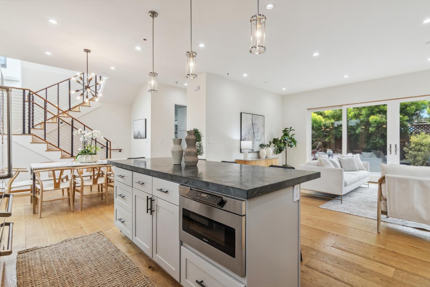 910 Cedar Street Berkeley, CA 94710 - Photo 31 of 39 an open kitchen with granite countertop a stove a sink a dining table and chairs with wooden floor