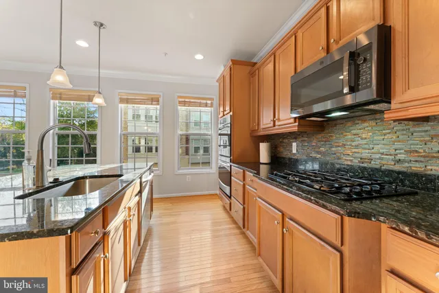 a kitchen with stainless steel appliances kitchen island granite countertop a stove a sink and a microwave