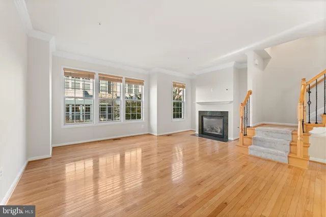 a view of a livingroom with wooden floor and a fireplace