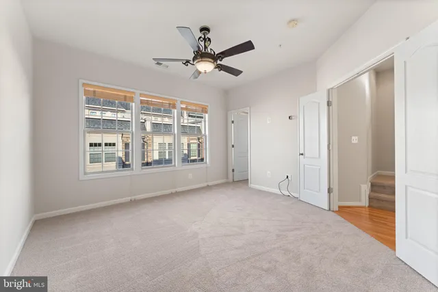 a view of a livingroom with a ceiling fan and window
