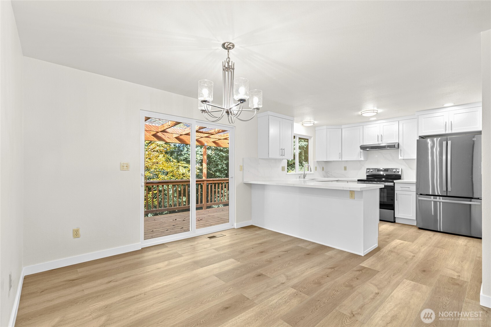 12718 Southeast 184th Place Renton, WA 98058 - Photo 12 of 34 a view of a kitchen with a sink and dishwasher a refrigerator with wooden floor