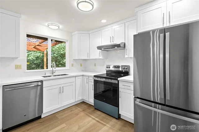 a kitchen with stainless steel appliances granite countertop a refrigerator sink and stove