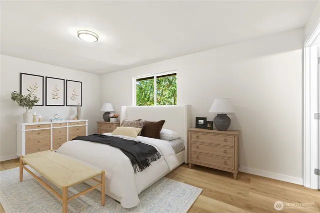 a bedroom with a white bed and dresser with mirror
