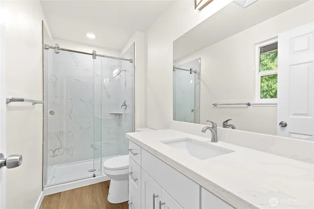 a bathroom with a sink a toilet and shower