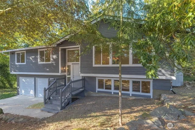 a view of a house with a yard and large tree