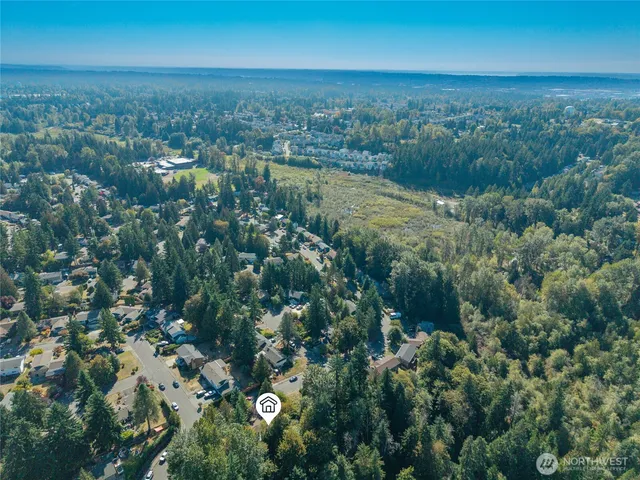 an aerial view of residential houses with outdoor space and trees