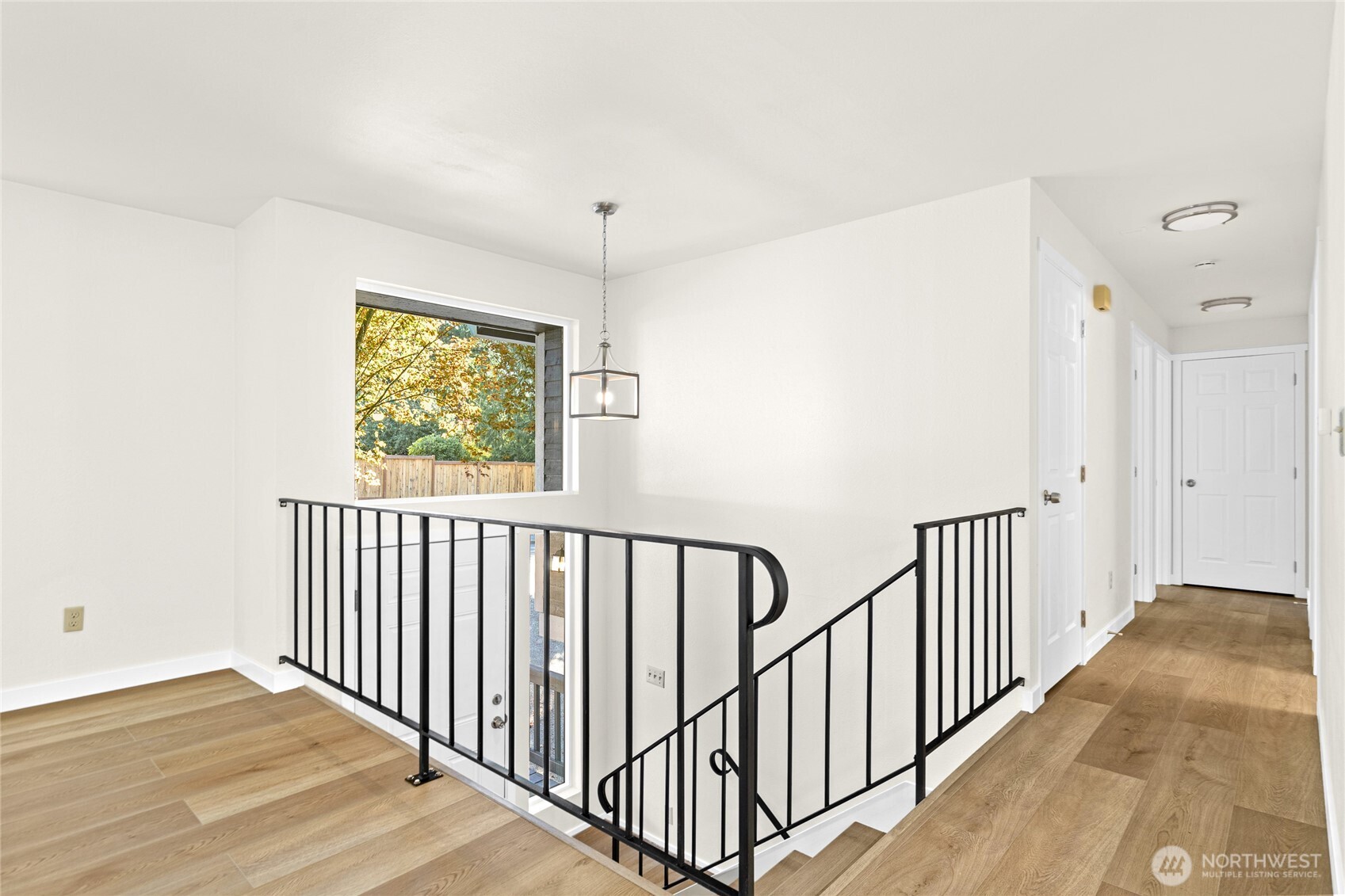 12718 Southeast 184th Place Renton, WA 98058 - Photo 5 of 34 a view of a hallway with wooden floor and windows