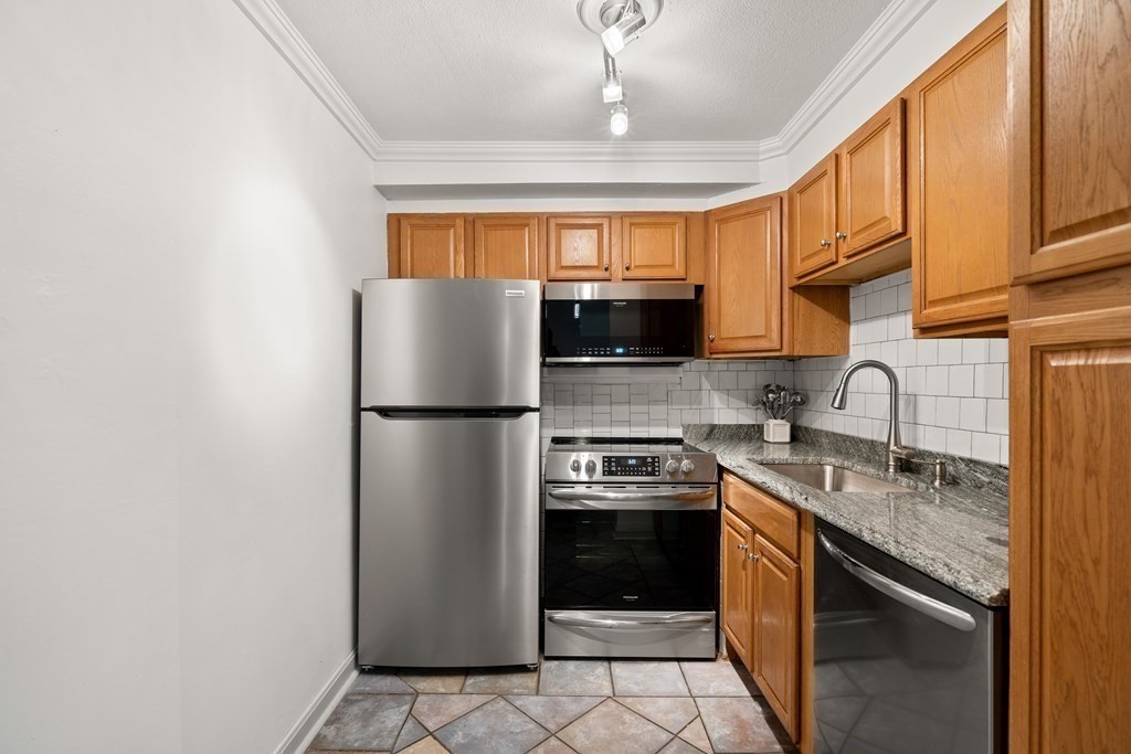 47 Will Drive, Unit 105 Canton, MA 02021 - Photo 6 of 13 a kitchen with stainless steel appliances granite countertop a refrigerator a stove a sink and a microwave