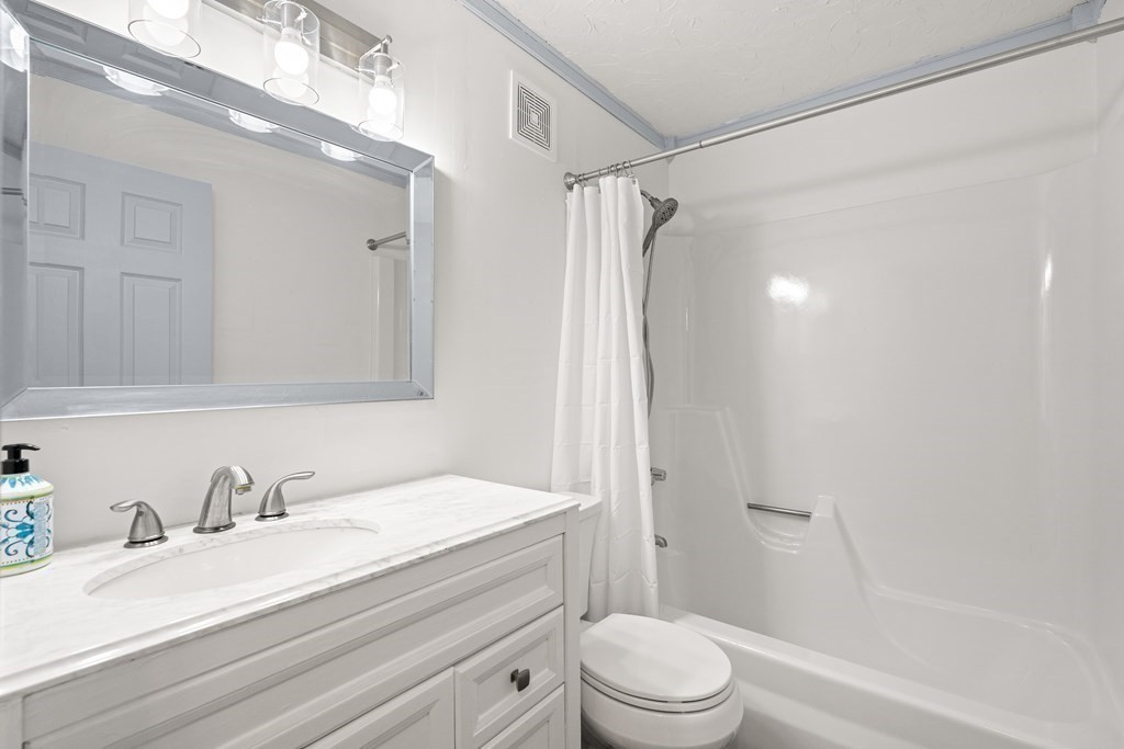 47 Will Drive, Unit 105 Canton, MA 02021 - Photo 9 of 13 a bathroom with a granite countertop sink toilet and shower