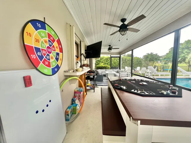a living room with patio furniture and a floor to ceiling window