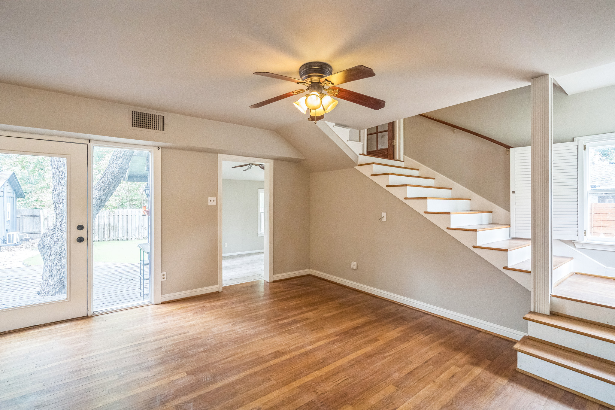 1402 Laurel Street, Unit B Georgetown, TX 78626 - Photo 7 of 21 Unfurnished living room featuring stairway, light wood-style floors, and ceiling fan
