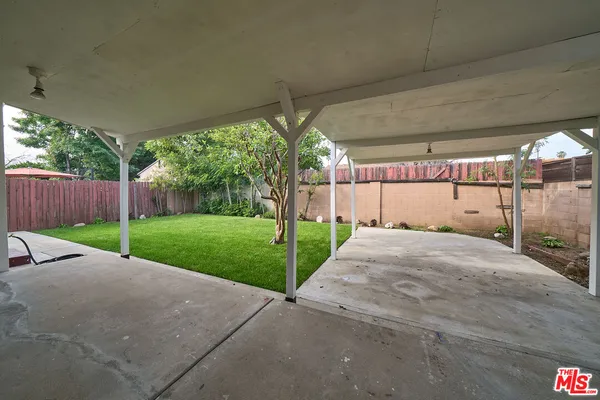 a view of a backyard with brick wall and plants