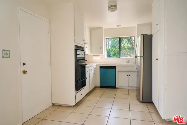 a kitchen with stainless steel appliances a refrigerator sink and cabinets