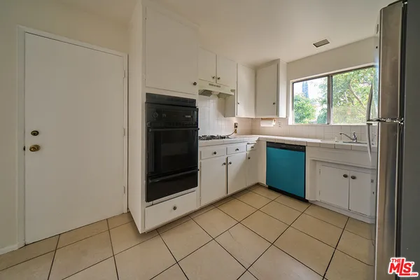 a kitchen with stainless steel appliances a sink cabinets and window