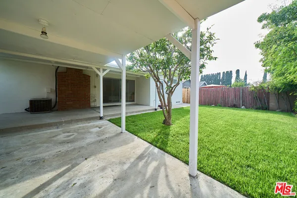 a view of a house with backyard and a tree