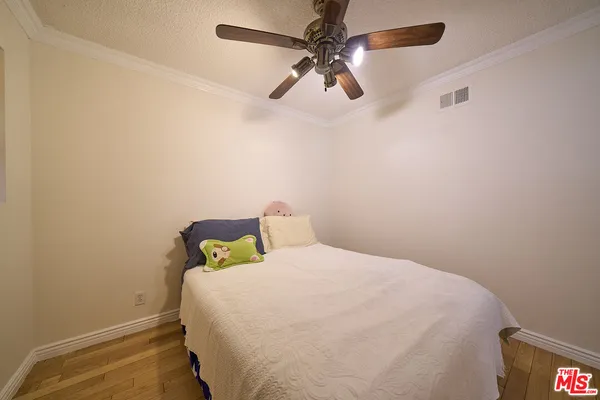 a bedroom with a bed and a fan