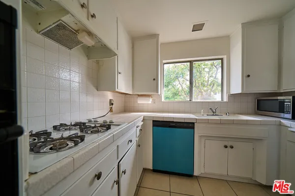 a kitchen with a stove sink and window