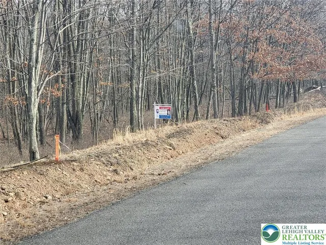 a view of a road with wooden fence
