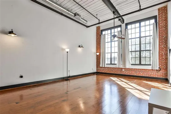 a view of an empty room with a window and wooden floor