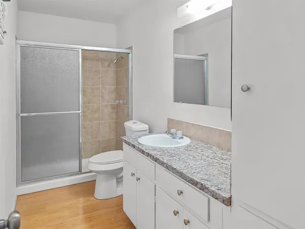 a bathroom with a granite countertop sink toilet and shower