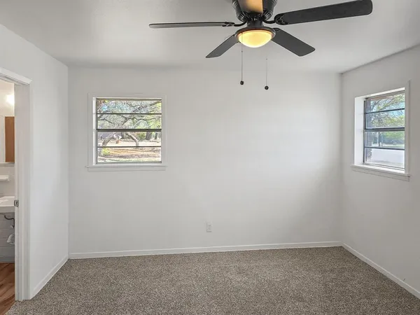 an empty room with closet and fan